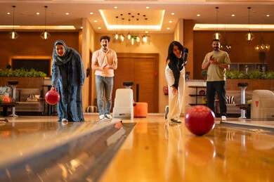 Saudi Friends Playing Bowling in Modern Entertainment Center