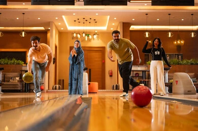 Arab Friends Playing Bowling in Modern Indoor Alley