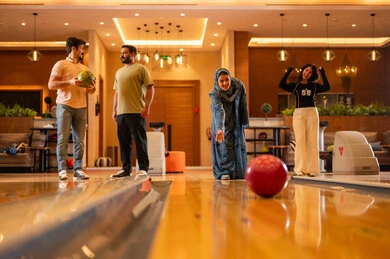 Saudi Friends Playing Bowling in Modern Entertainment Center