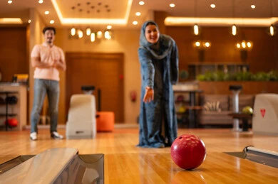 Saudi Woman Playing Bowling at Indoor Entertainment Center