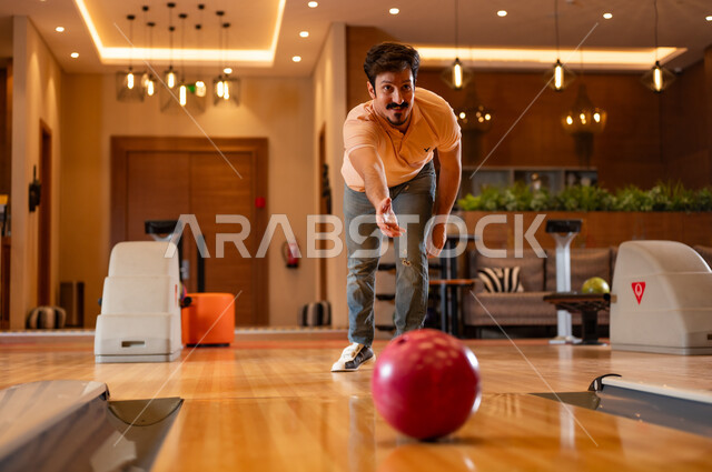 Saudi Man Playing Bowling at Indoor Recreation Center