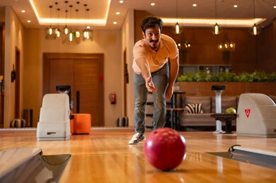 Saudi Man Playing Bowling at Indoor Recreation Center
