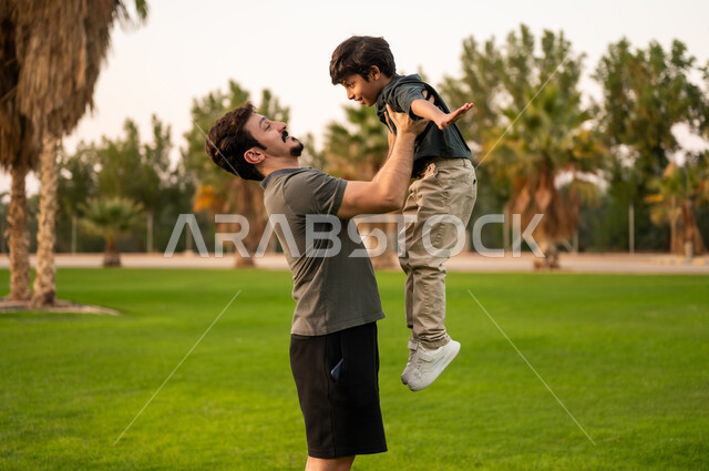 Arab Father Lifting Son in Park at Golden Hour