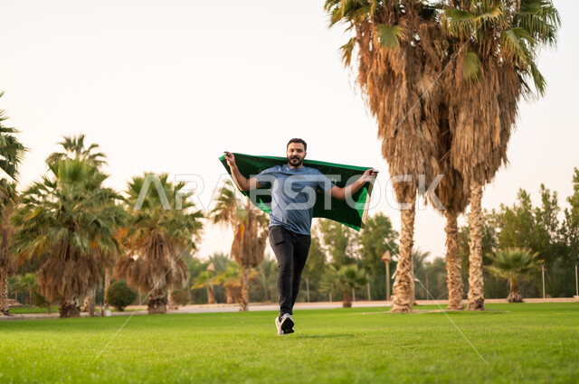 Saudi Man Running with National Flag in Park