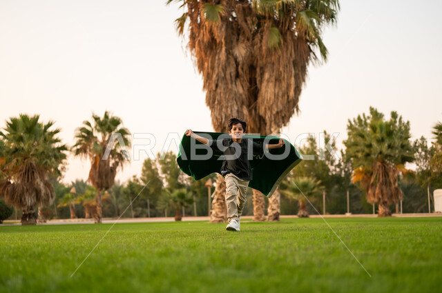 Saudi Boy Running with National Flag in Public Park