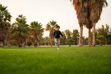 Arab Boy Running in Green Park at Golden Hour