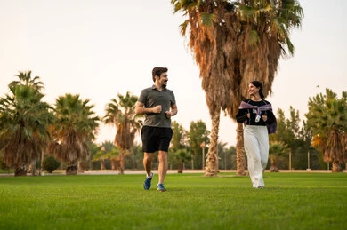 Arab Couple Jogging in Green Park with Palm Trees