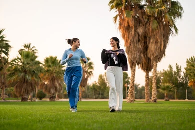 Arab Women Jogging in Outdoor Park with Palm Trees