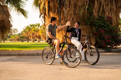 Middle Eastern Couple Cycling in a Public Park High Five