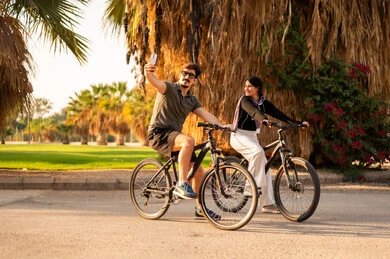 Arab Couple Cycling in Park at Golden Hour