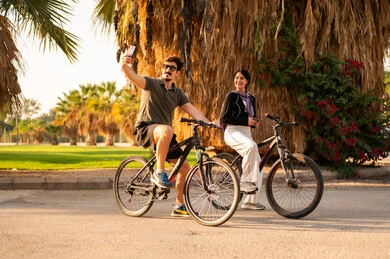 Arab Couple Taking Selfie While Cycling in Park