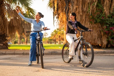 Saudi Women Cycling in Park During Golden Hour