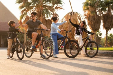 عائلة عربية تركب الدراجات الهوائية وقت الغروب