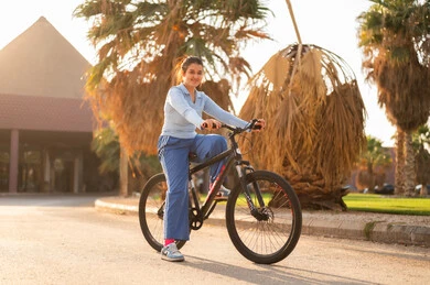 Arab Woman on Bicycle in Park at Sunset