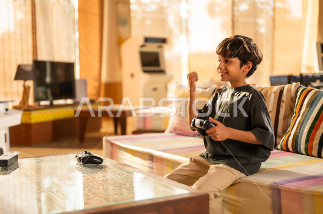 طفل سعودي يحتفل أثناء لعب ألعاب الفيديو في المنزل