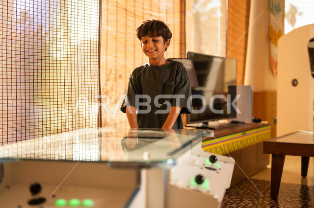 Young Saudi Boy Playing Arcade Game at Home