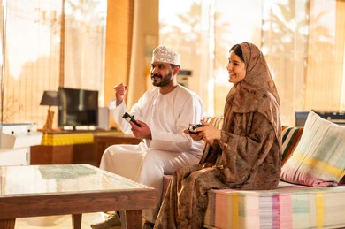 زوجين عمانيين يلعبان ألعاب الفيديو في المنزل