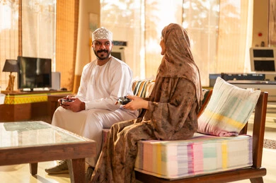 Omani Couple Playing Video Games in Living Room