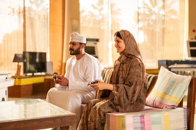 Omani Couple Playing Video Games in Living Room