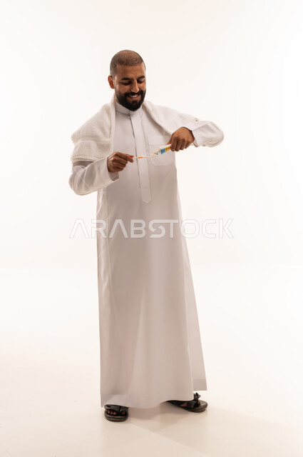 رجل سعودي يضع معجون الأسنان على الفرشاة في الاستوديو