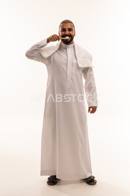 Saudi Man in Thobe Brushing Teeth on White Background