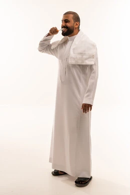 رجل سعودي ينظف أسنانه بالفرشاة بالثوب التقليدي