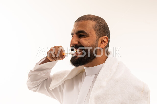 Saudi Man Brushing Teeth in Traditional White Thobe