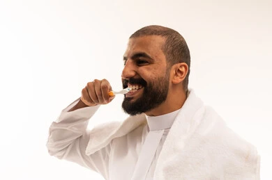 Saudi Man Brushing Teeth in Traditional White Thobe