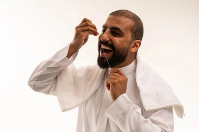 Saudi Man Using Dental Floss White Background