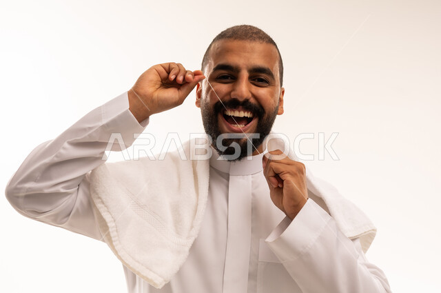 رجل سعودي يستخدم خيط الأسنان بالثوب التقليدي