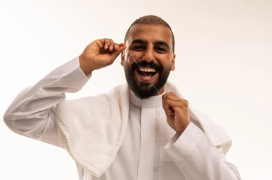 Saudi Man Using Dental Floss in Traditional Thobe