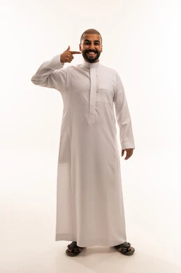 رجل سعودي بالثوب الأبيض يشير إلى ابتسامته