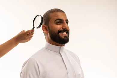 فحص شعر وفروة رأس رجل سعودي بالعدسة المكبرة