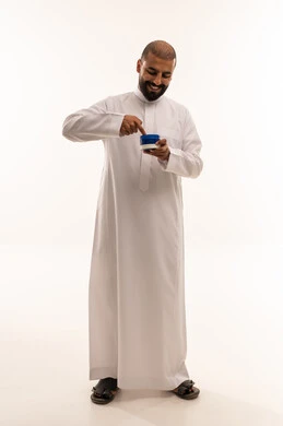 رجل سعودي بالثوب التقليدي يستخدم كريم البشرة