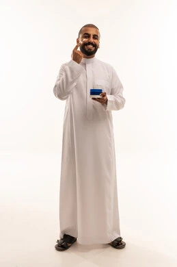 Saudi Man in Thobe Applying Facial Moisturizer