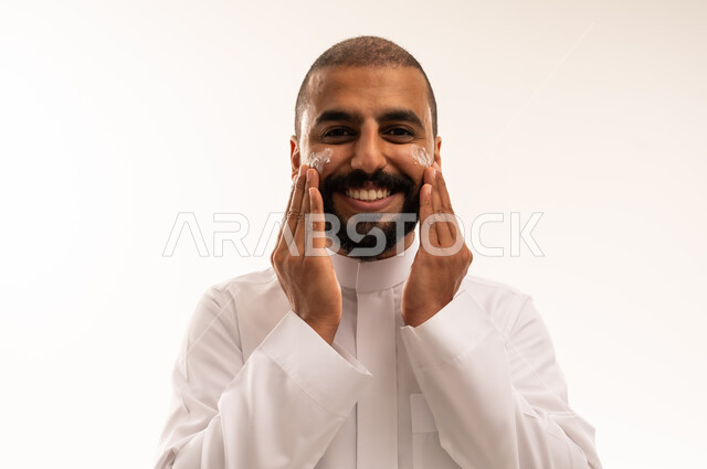 Saudi Man Applying Face Cream in White Thobe
