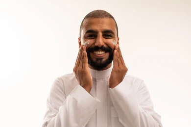 Saudi Man Applying Face Cream in White Thobe
