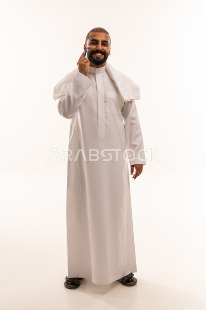 Saudi Man Shaving with Razor in Traditional Thobe