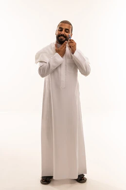 Saudi Man Shaving Beard in Traditional White Thobe