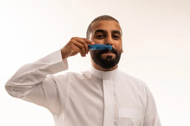 Saudi Man Grooming Mustache in White Thobe