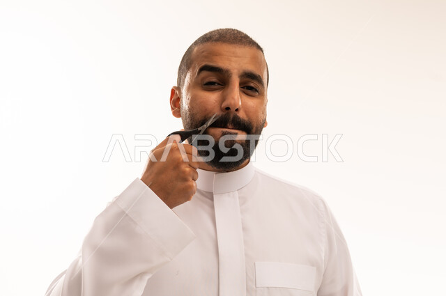 Saudi Man Trimming Mustache with Scissors on White Background