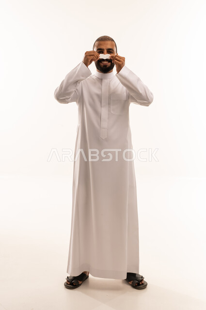 Saudi Man in White Thobe Holding Paper Mustache