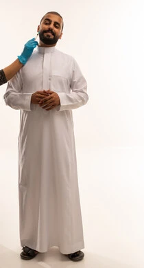 رجل سعودي يتلقى حقنة تجميلية بالثوب الأبيض
