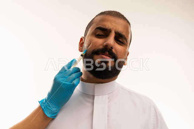 Saudi Man Receiving Facial Injection in White Thobe