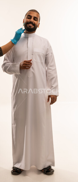 رجل سعودي بالثوب يحصل على حقنة تجميلية