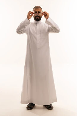 رجل سعودي يرتدي الثوب التقليدي ويعدل نظارته الطبية