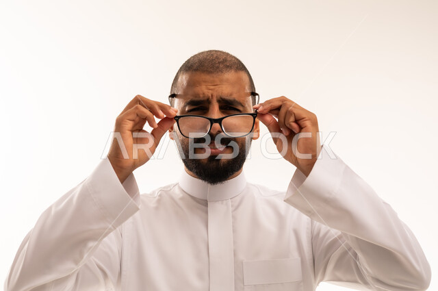 Saudi Man in Thobe Holding Eyeglasses Studio Shot