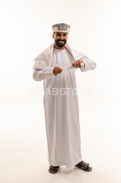 رجل عماني بالزي التقليدي يحمل المسواك