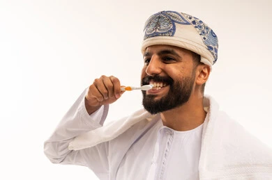 Omani Man Brushing Teeth in Traditional Dress