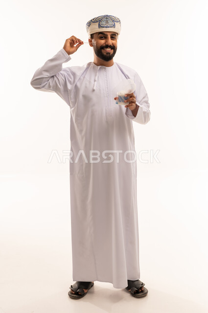 Omani Man in Traditional Dress Using Cotton Swab